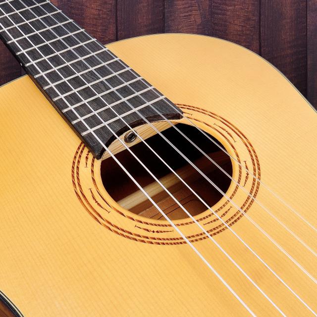 3/4 classical guitar featuring solid spruce top and engraved rosette